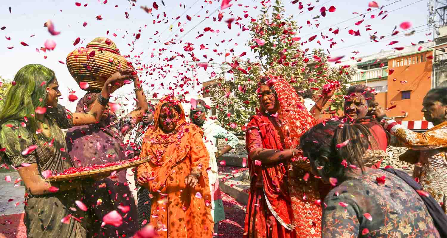 Prayagraj: Members of Kinnar Akhara play with colours and flower petals during Holi celebration, in Prayagraj, Thursday