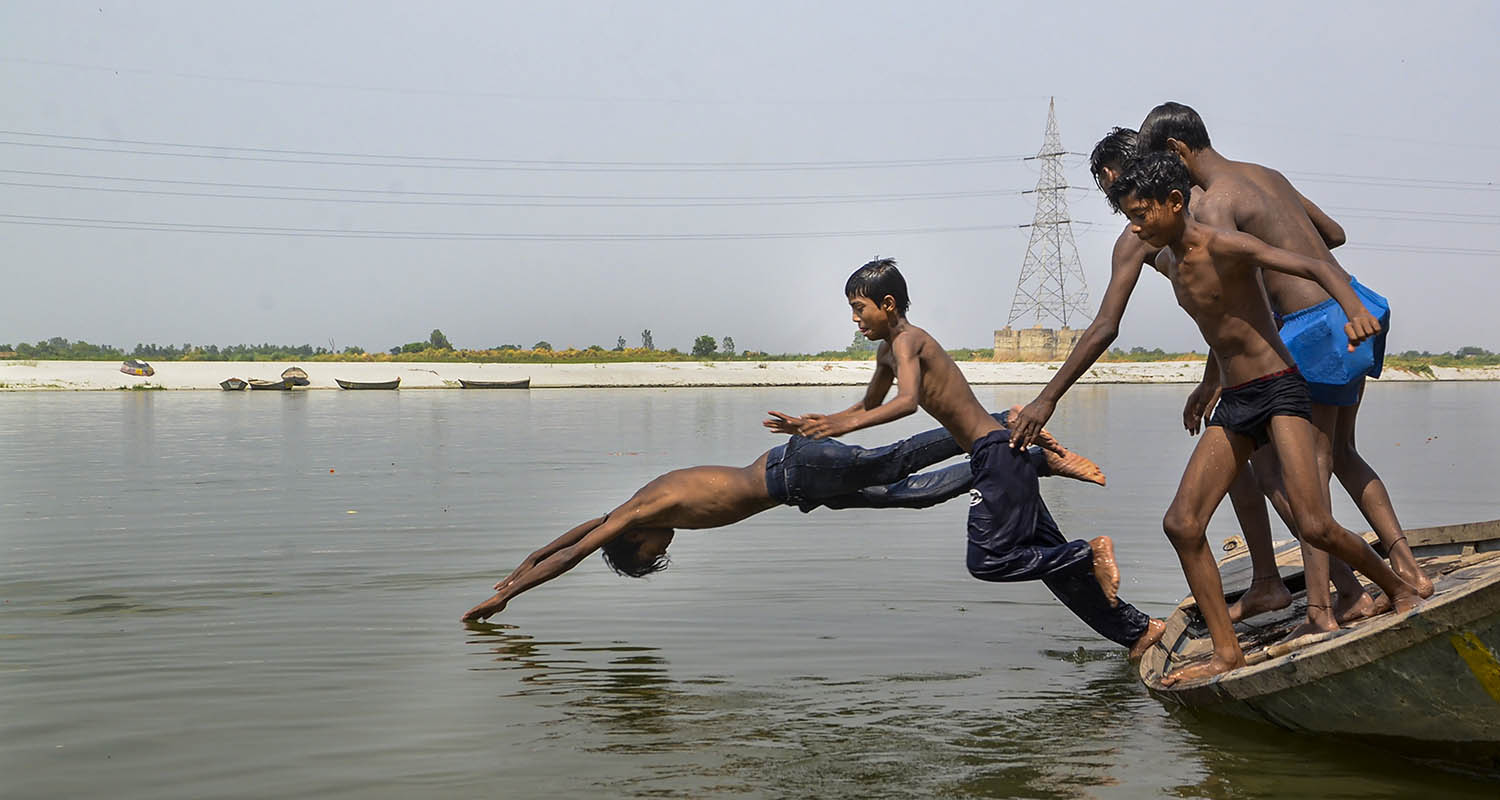 Kanpur: Children dive into the Ganga river from a boat on a hot summer day, near Magazine Ghat, in Kanpur, Uttar Pradesh, on Friday.