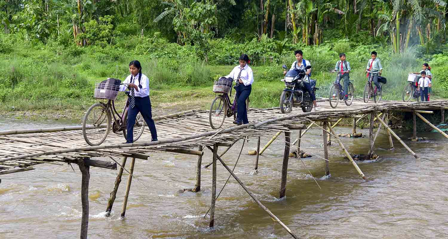 Students cross a bamboo bridge over a river in the Hahim area, Kamrup district, Assam, on Thursday.