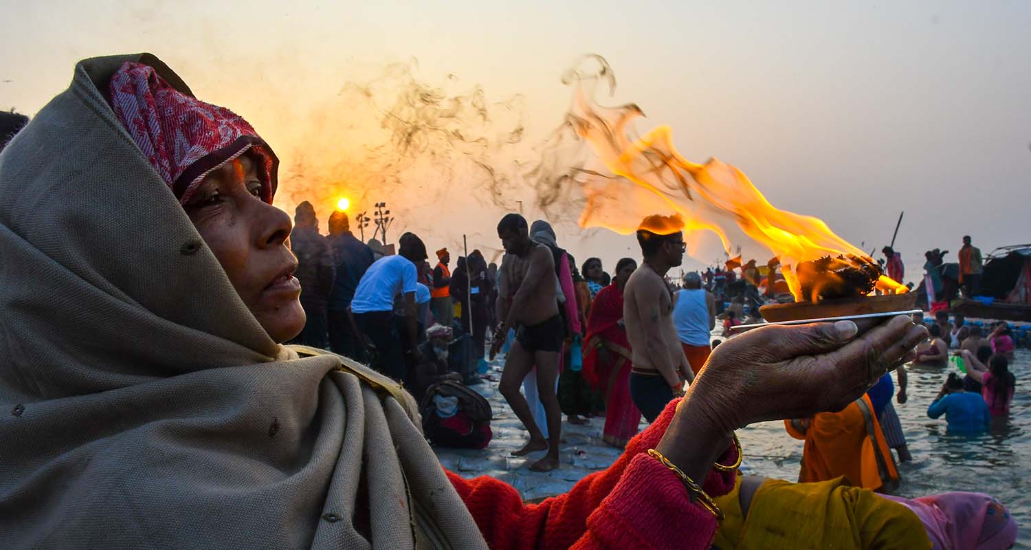 A woman performs rituals as people take a holy dip at the Sangam on the occasion of ‘Makar Sankranti’ festival, during the ongoing ‘Magh Mela’, in Prayagraj, on Wednesday.