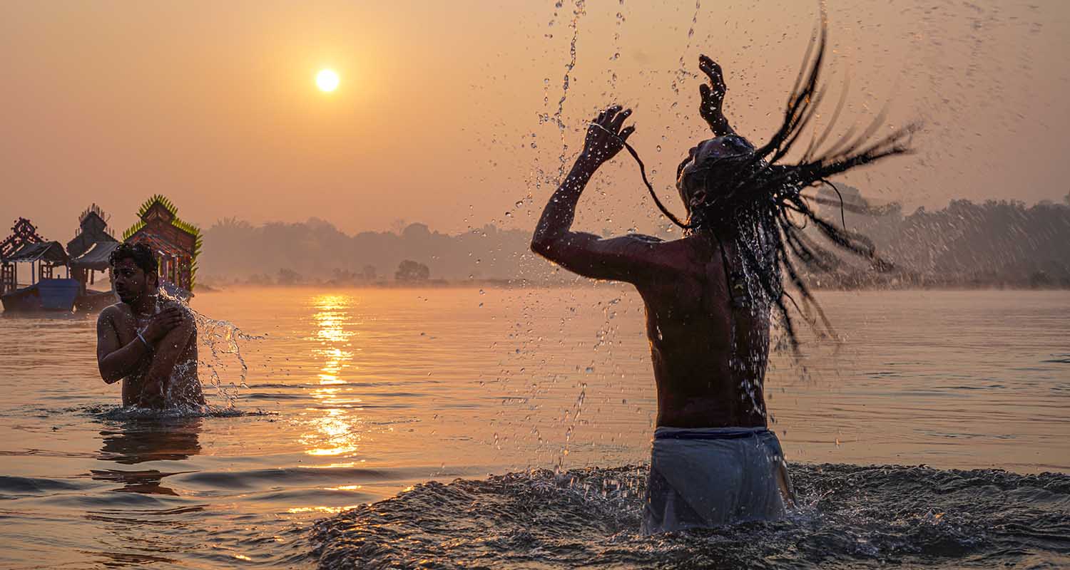 A woman performs rituals as people take a holy dip at the Sangam on the occasion of ‘Makar Sankranti’ festival, during the ongoing ‘Magh Mela’, in Prayagraj, on Wednesday.